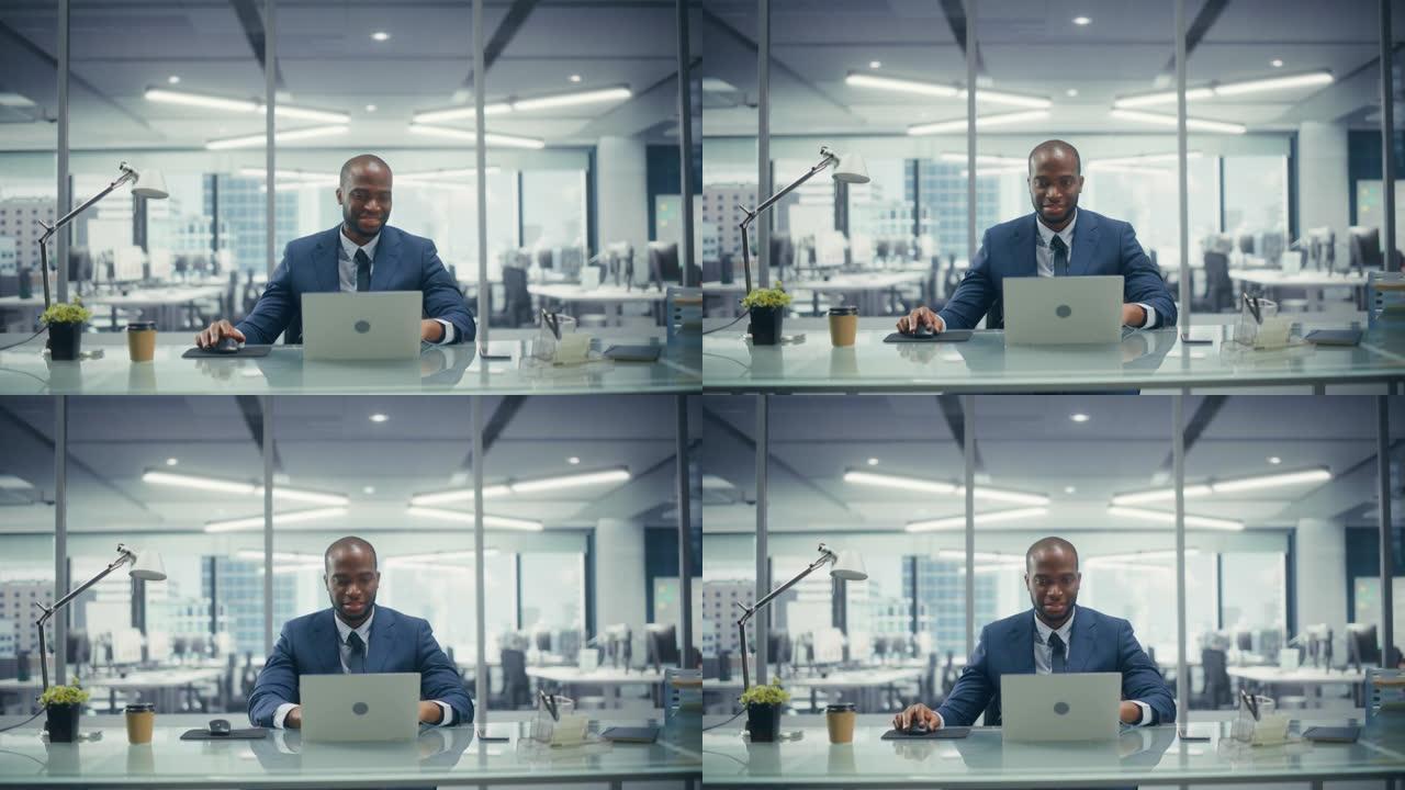 成功的黑人商人穿着量身定制的西装，在俯瞰大城市的顶层办公室的笔记本电脑上工作。管理环境、社会和公司治