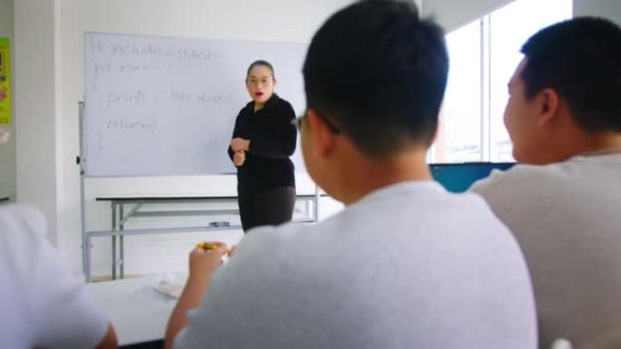 老师教高中生如何在学校课堂上对机器人项目进行编码和编程。