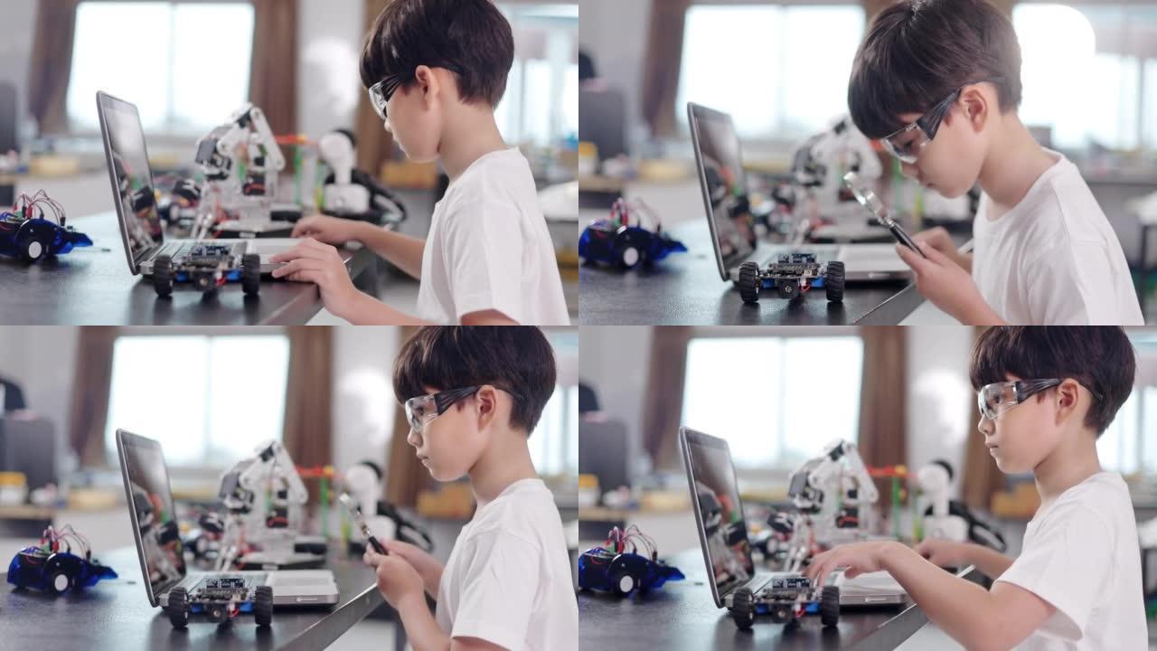 一个小学生在笔记本电脑上编程机器人