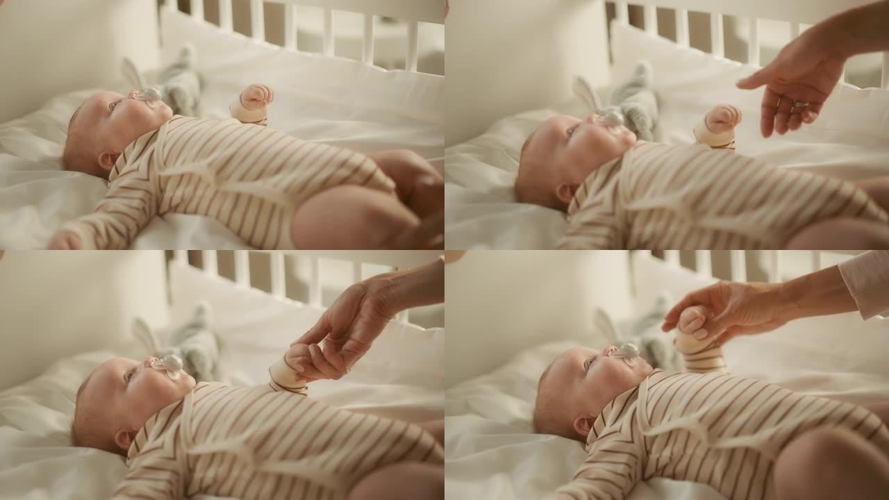 真实的特写镜头，母亲在婴儿床中抚慰并轻轻按摩新生儿。白人新生儿蹒跚学步的孩子在孩子们的卧室里。童年、