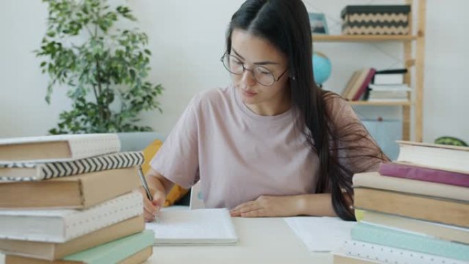 勤奋学生作文的慢动作坐在办公桌前，在家看书