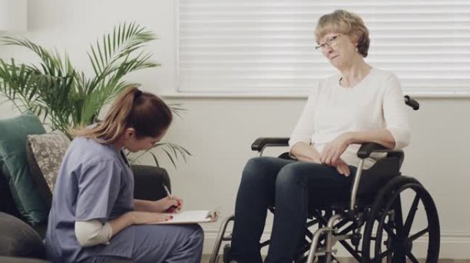 4k视频片段，一名女护士坐下来与一名老年患者进行咨询