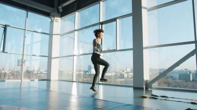 现代健身房用跳绳运动的苗条女运动员的慢动作