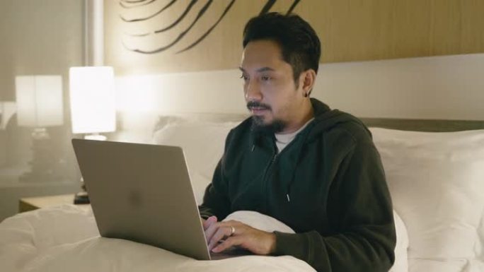 时髦商人深夜用笔记本电脑工作。