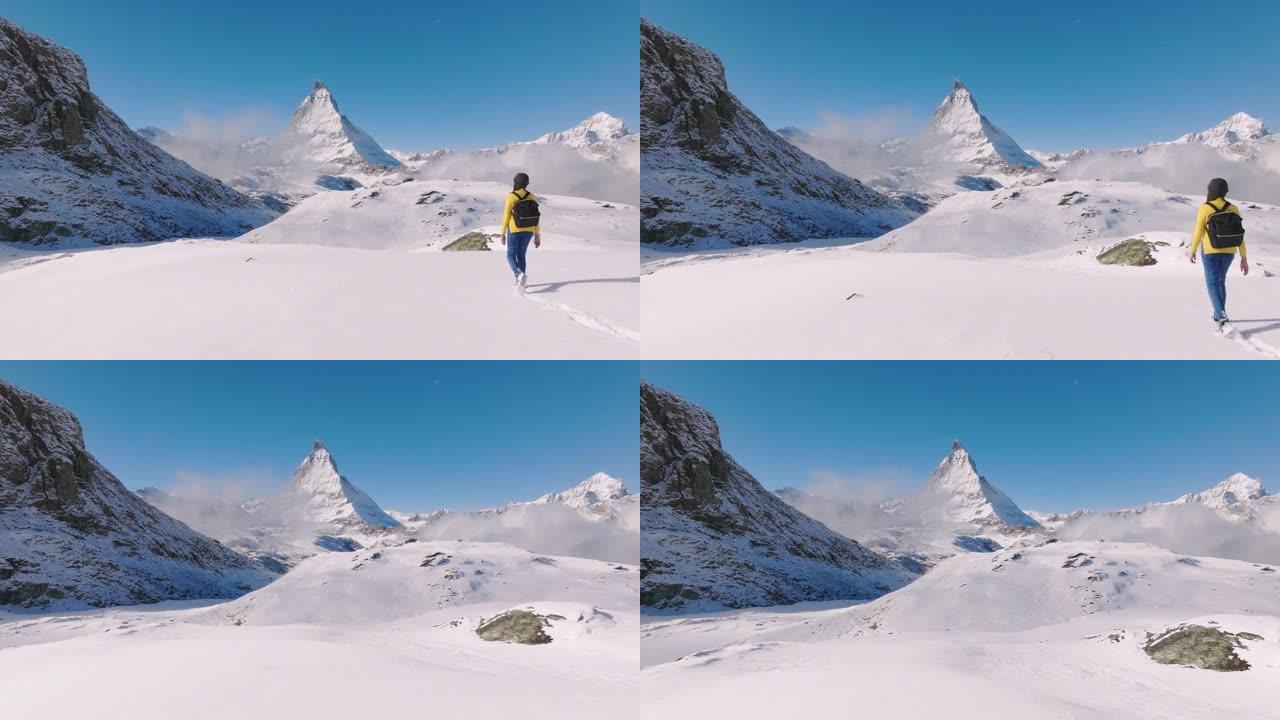 旅行者在瑞士马特宏峰山顶行走的年轻女性的空中无人机视图。大自然中的幸福。具有多样性概念的体验式旅行。