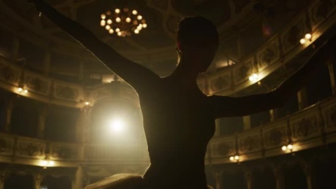 一位年轻优美的古典芭蕾舞女舞者穿着白色芭蕾舞短裙的电影特写镜头正在经典剧院舞台上表演舞蹈，并在演出开