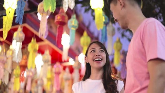 SLO MO年轻的亚洲夫妇在loi kathong节旅行，背景是五颜六色的灯笼
