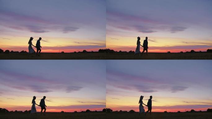 追踪成年夫妇在田野里走到日落时牵手的慢动作镜头
