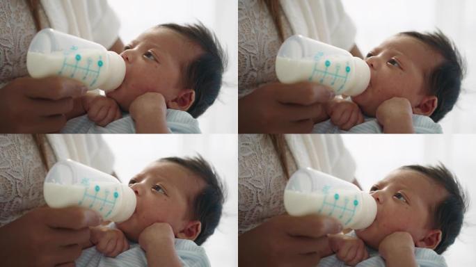 母亲在家中用奶瓶喂养男婴