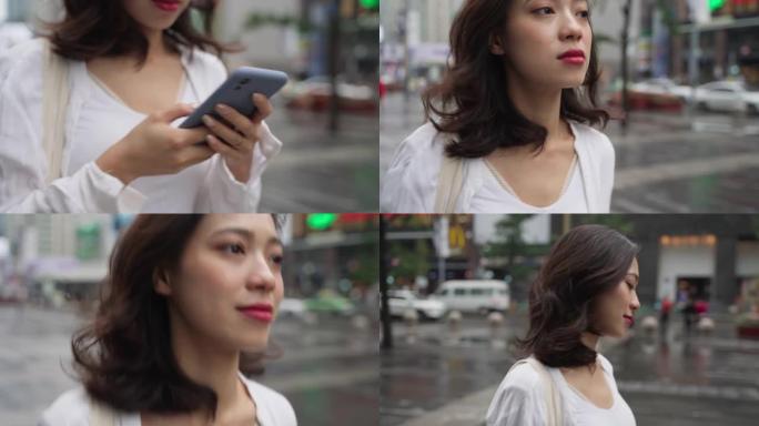 女人在城市街道上使用手机行走