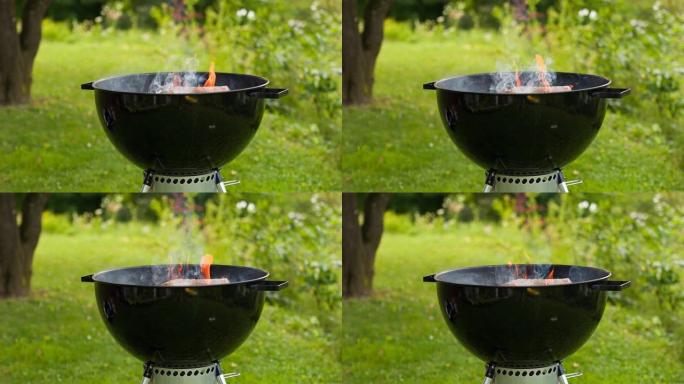 在烧烤烤架中燃烧木材，准备热煤在后院烧烤
