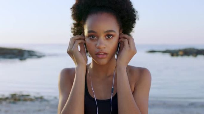 面对，音乐和沙滩，一个黑人妇女在日落时在户外自然环境中聆听音频。肖像，耳机和迷人的年轻女性在海边或海