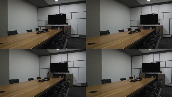 办公室里有电视监视器、桌椅的空房间的全景