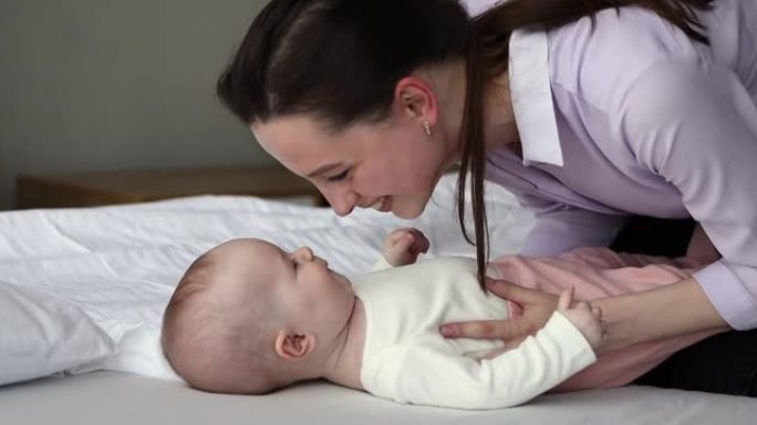 年轻的母亲为新生婴儿提供温暖和爱抚