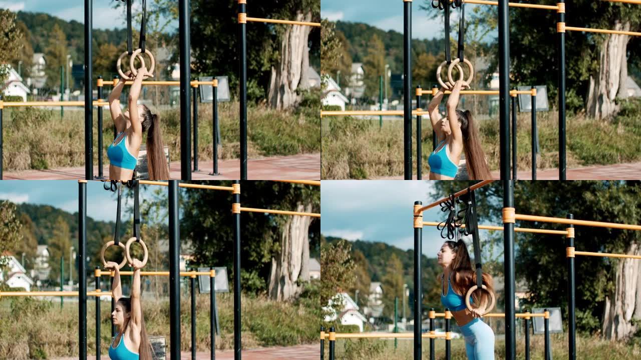 SLO MO年轻女子在户外健身公园的戒指上锻炼