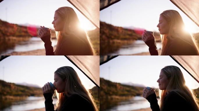 4k视频片段，一名年轻女子在露营旅行中坐着喝杯咖啡