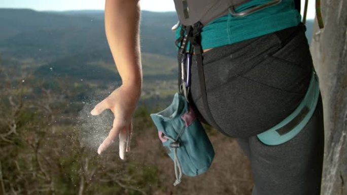 特写: 女子攀岩从手指上甩掉多余的镁。