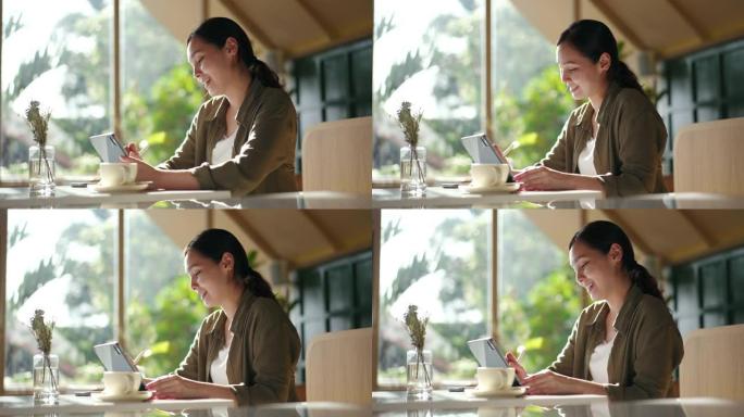 亚洲妇女在咖啡店使用笔记本电脑