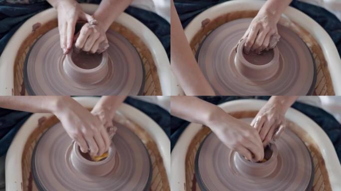 陶器，艺术品和手放在陶工轮上，艺术家在创意班，工作室或工作室中旋转粘土。从事陶瓷设计，工艺或创作的雕