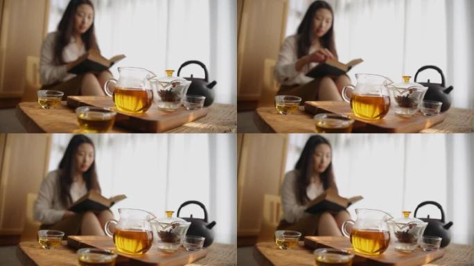 亚洲女子在家放松看书喝红茶