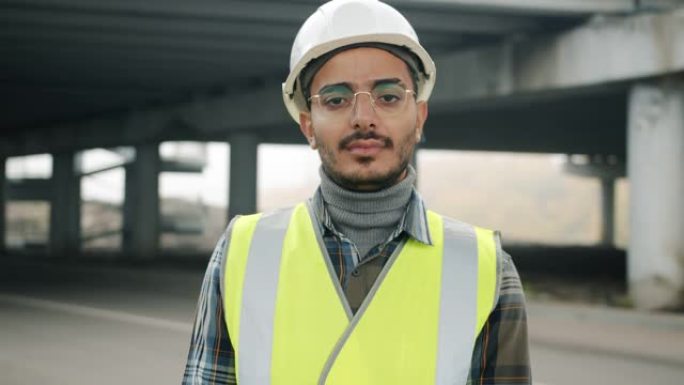 穿着制服站在工业区的阿拉伯年轻人的慢动作肖像