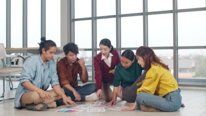 亚洲休闲服装青年创意小组讨论商务头脑风暴会议创意移动应用软件设计项目计划在办公室地板上布置。