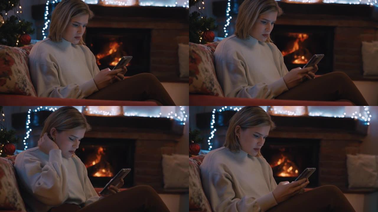 SLO MO DS年轻女子在圣诞节假期装饰的温暖客厅中使用智能手机