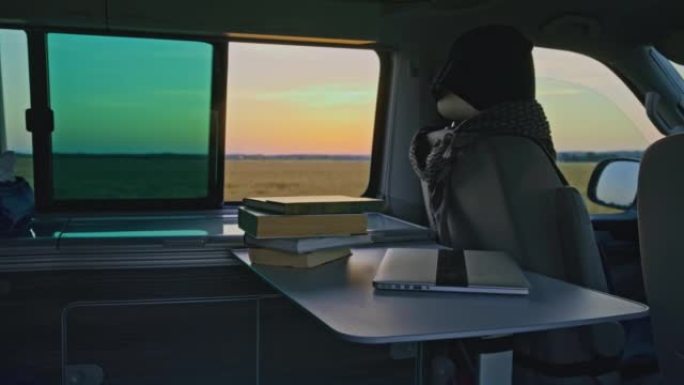 日落时分，露营车内桌子上的DS书籍和笔记本电脑