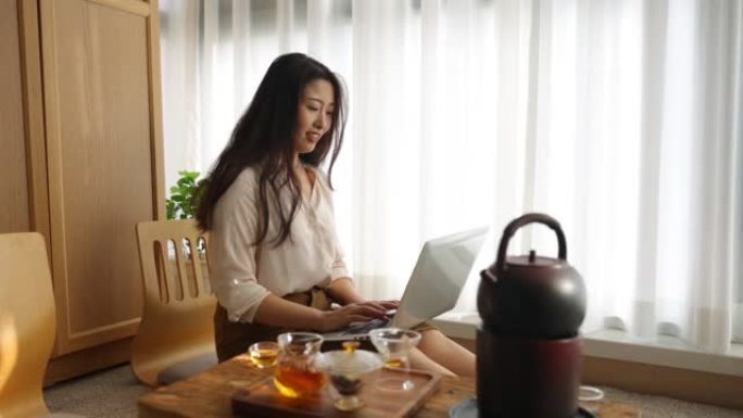 在茶室的笔记本电脑上工作的亚洲女性