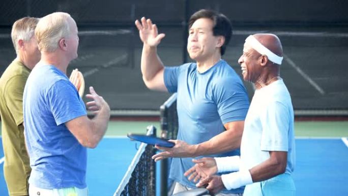 一群高级男子在pickleball球场上握手