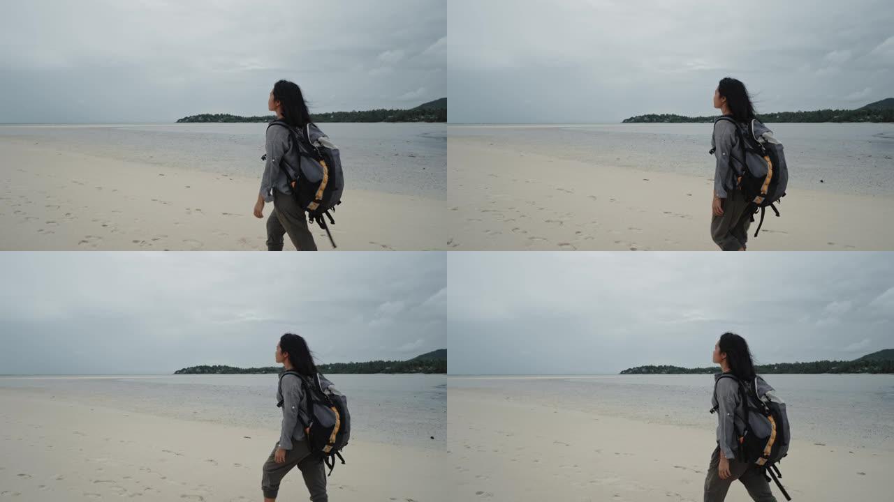 孤独的女人走在沙滩上