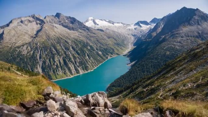 高高的山湖山谷上方雄伟的山涧鸟瞰图，周围环绕着雪山