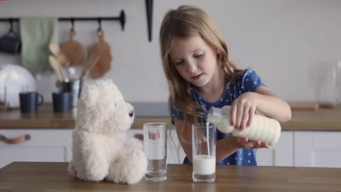 女孩将牛奶倒入自己和玩具熊的眼镜中