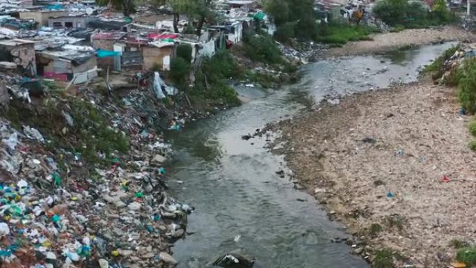 水污染。非洲贫民窟附近的河流和水路中可怕的塑料污染的空中平移视图