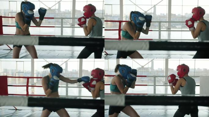 在体育馆内，戴着防护头盔和手套拳击的妇女的慢动作