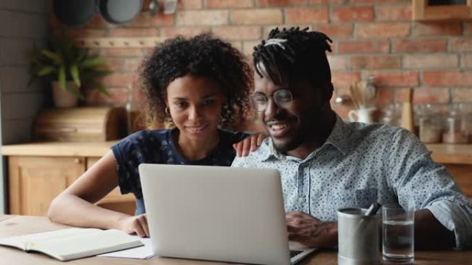 非洲夫妇使用笔记本电脑在互联网上讨论购买