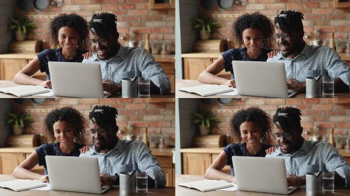 非洲夫妇使用笔记本电脑在互联网上讨论购买