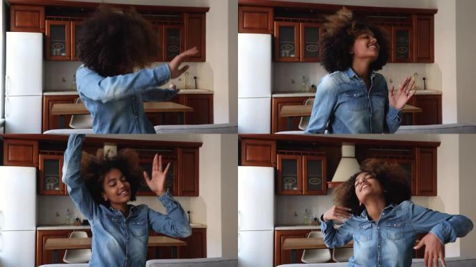 活泼的非洲少女独自在舒适的厨房跳舞