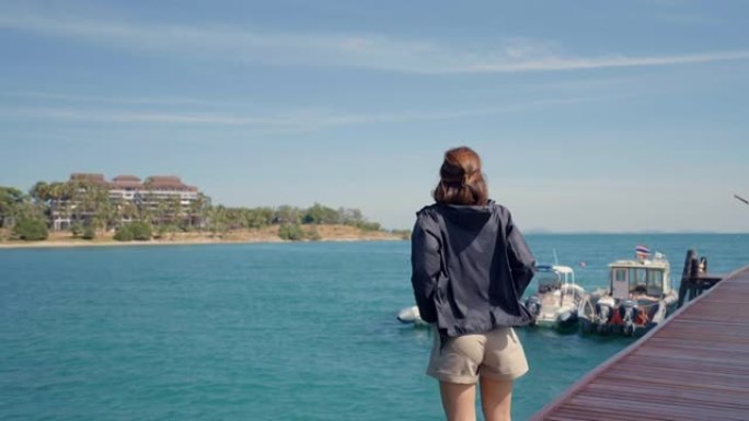 开朗的女人从海滩望向大海。