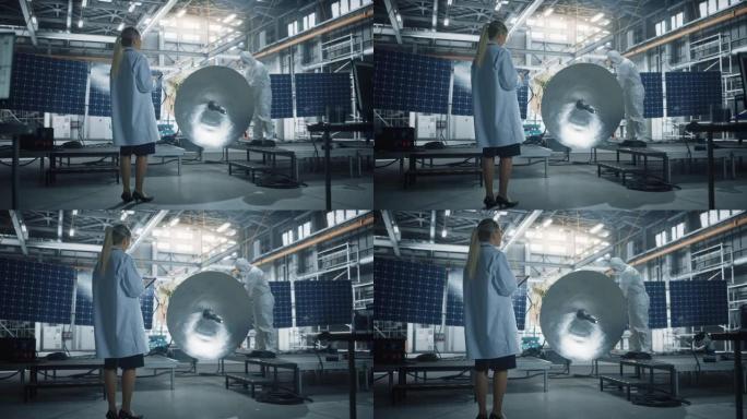 女工程师在进行卫星建设时使用平板电脑。航空航天局制造设施: 科学家为太空探索，观测任务建造，组装航天