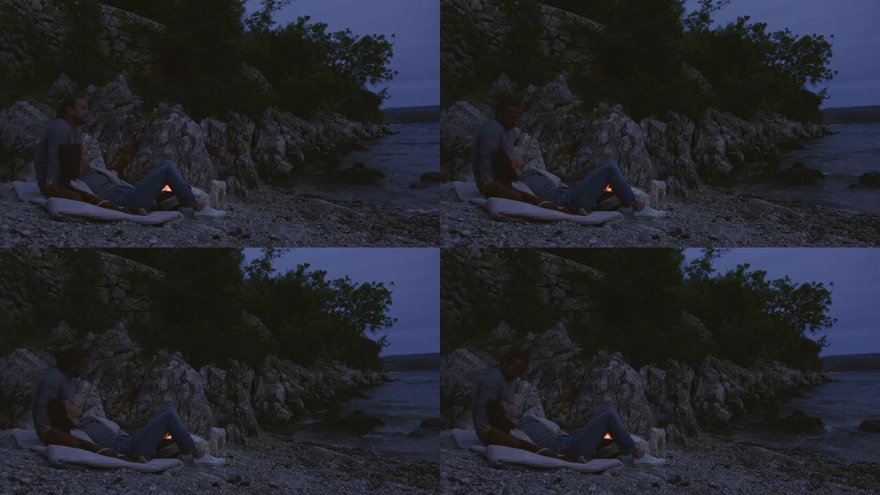 日落期间，情侣在海岸上放松和拥抱
