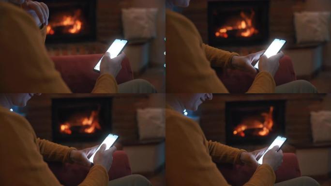 SLO MO DS Man在带壁炉的客厅里使用智能手机