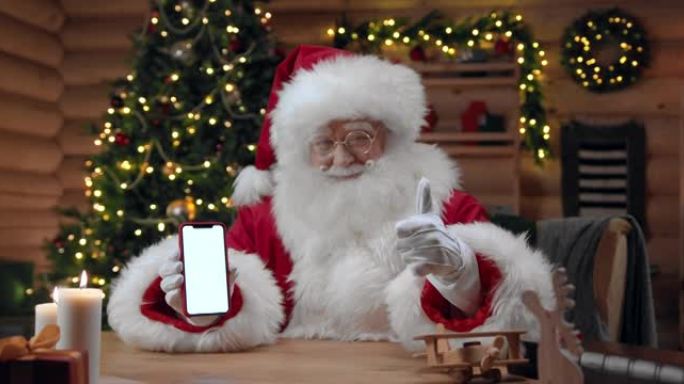 圣诞老人拿着一个空屏幕的智能手机，并在相机中显示拇指