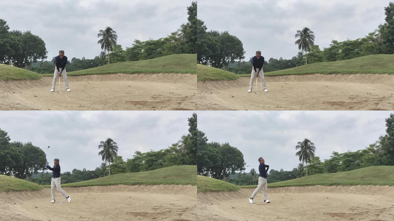 亚洲华裔高级高尔夫球手用铁棍在沙坑中击球