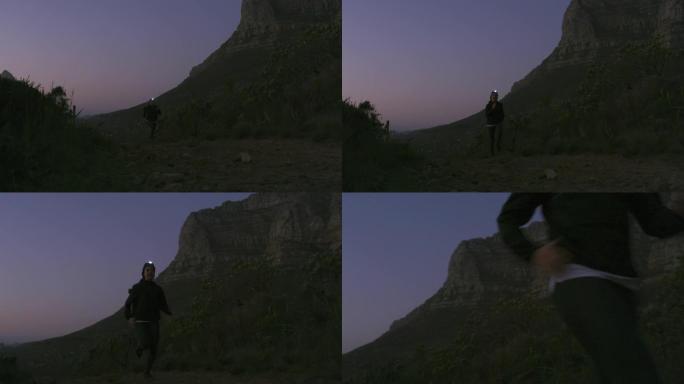 4k视频片段，一名妇女在山上奔跑时戴着头灯