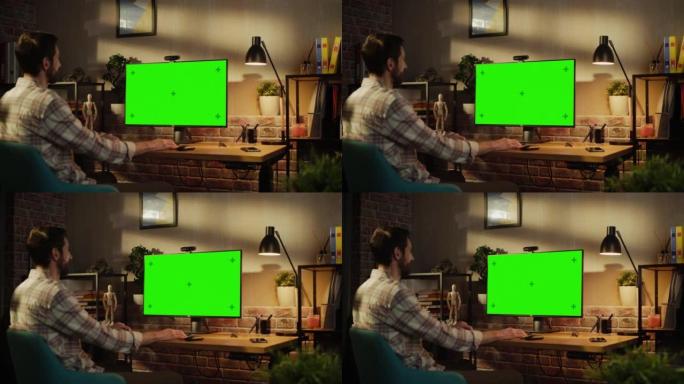 办公室员工在家工作，在带有绿屏模拟显示器的台式计算机上进行视频通话。男人坐在客厅里，晚上与朋友和家人