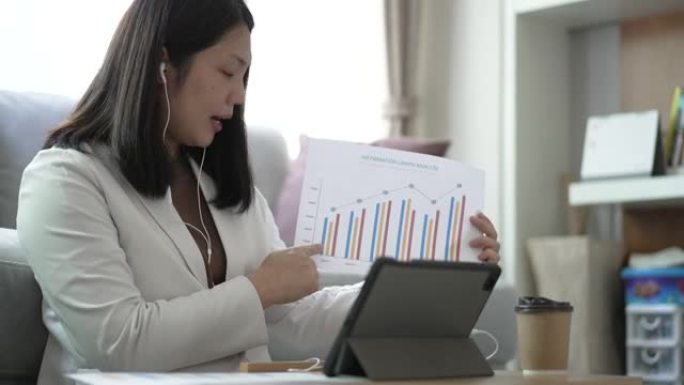 女人在家工作，用图形文件在数字平板电脑上开会