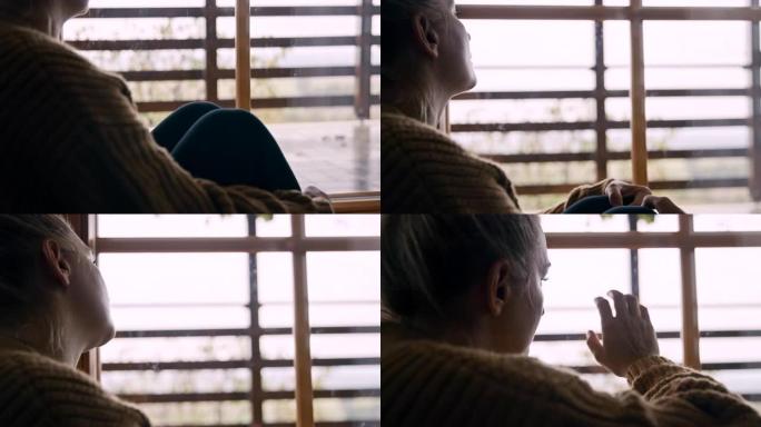 SLO MO孤独的女人透过窗户看