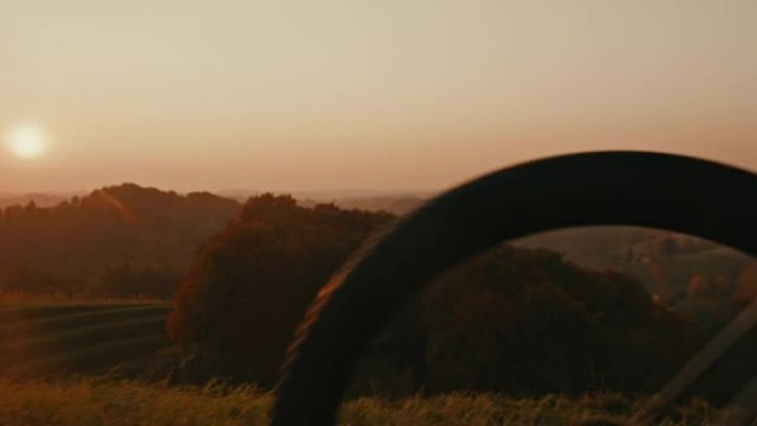 SLO MO山地自行车手在日落时骑在山顶上