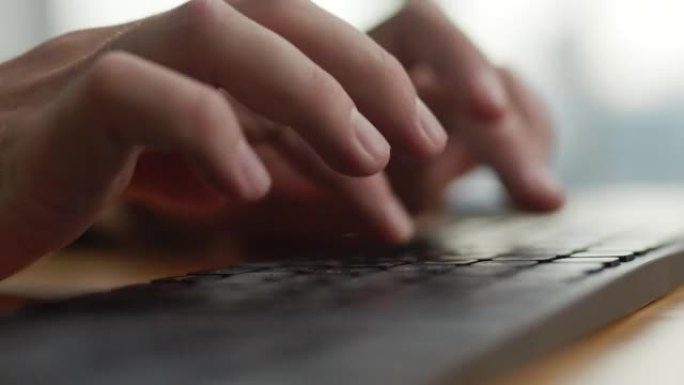 双手年轻商人忙于电脑键盘微距拍摄。特写男人坐在家庭办公室的办公桌上，使用PC软件应用程序技术在线工作